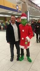 Grinch takes a photo with a happy traveller 